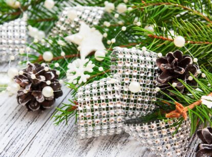 Christmas decor featuring pine branches, pine cones, beads, and rhinestones arranged together.