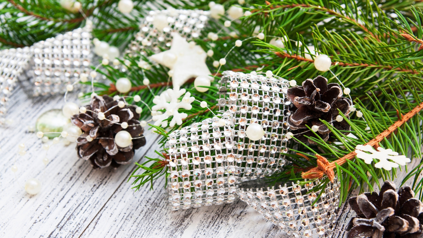 Christmas decor featuring pine branches, pine cones, beads, and rhinestones arranged together.