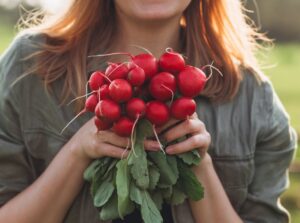 A close-up shot of a person holding fresh crops that shows what to plant vegetables November